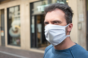 Black man wearing a white mask in a city street, coronavirus covid prevention concept