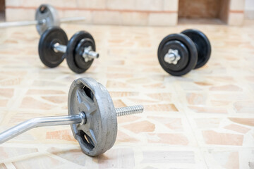 Barbell and dumbell on the floor for home workout