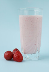 Natural yogurt made from fresh strawberries in a glass glass on a blue background. Diet. Selective focus. Summer treat. Copy space
