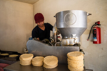 young man selling tortillas of nixtamal