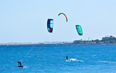 Kitesurfer  surfano sul mar Mediterraneo con aeroporto sullo sfondo