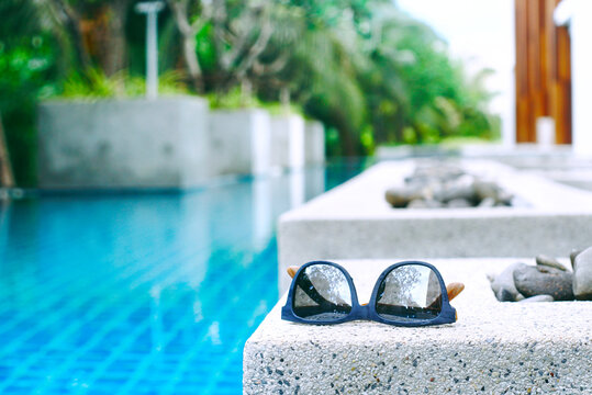 Sunglasses with background  swimming pool, picture have space for idea.