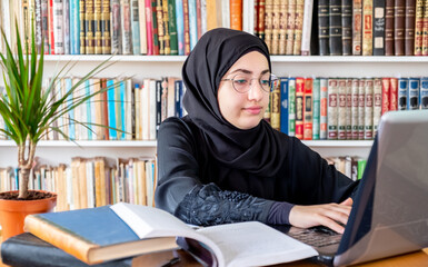 Arabic muslim woman using laptop for online meetings and studying