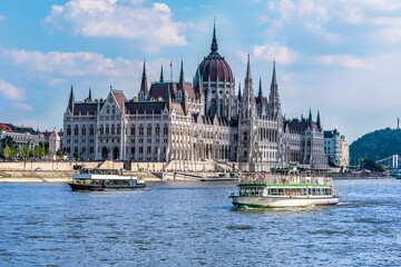 Fototapeta na wymiar Ferry boats and the view down the east bank of the River Danube in Budapest during summertime