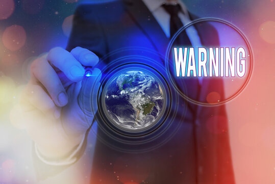 Writing note showing Warning. Business concept for statement or event that indicates a possible or impending danger Elements of this image furnished by NASA
