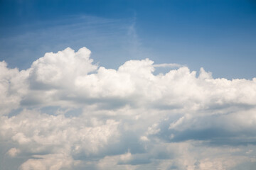 White cumulus clouds formation in blue sky in summer sunny day