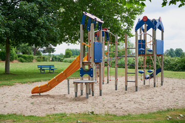modern empty playground on a cloudy day beside trees