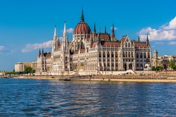 Fototapeta na wymiar A view of the Parliament building on the eastern shore of the River Danube in Budapest from a ferry boat in the summertime