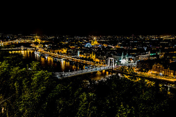 Fototapeta premium A view of the bridge over the River Danube from the foot of the Liberty Statue at night in the summertime