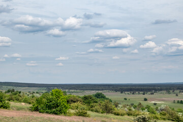 Fototapeta na wymiar Green spring panoramic countryside rural Ukraine view with grey dramatic sky. Kitsevka, Kharkiv region landscape