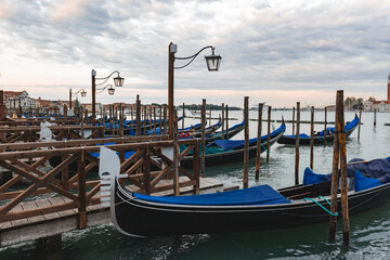 Fototapeta na wymiar Gondolas anchored by Piazza San Marco with San Giorgio di Maggiore church in Venice,