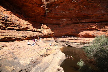 Tourists sitting and swimming at Garden of Eden Waterhole in Kings Canyon outback central Australia