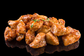 Aromatic chicken pieces with thyme with reflection, isolated on black background