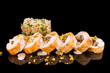 A gourmet delicious chicken roll with pistachios with reflection, isolated on black background