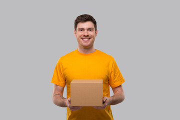 Delivery Man with Box in Hands. Yellow Tshirt Delivery Boy. Home Delivery. Quarantine Hero. Man Smiling