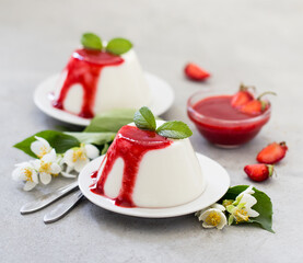 Cream dessert panna cotta vanilla with strawberry sauce on a light background