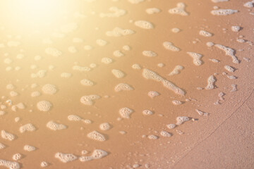white foam from the sea wave remained in the sand