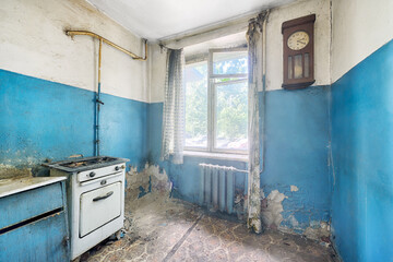 Old ugly abandoned empty kitchen in a residential building. The interior of the collapsing room of...