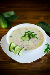 summer cucumber soup with vegetables on a wooden table