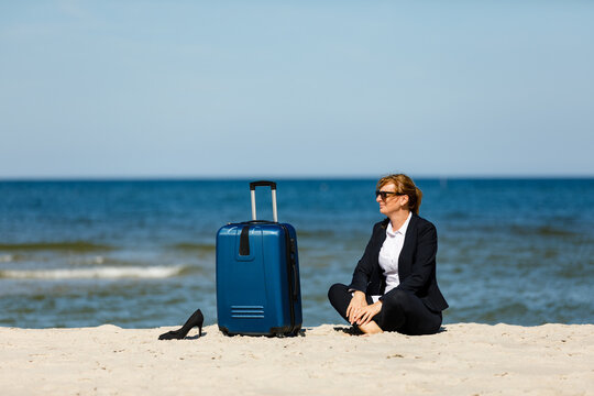 Businesswoman sitting on beach
