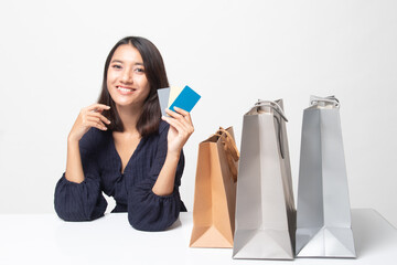 Young Asian woman with shopping bag and blank card.