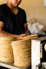 tortillas stacked on a tortilla machine