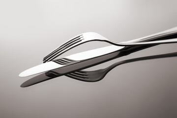 fork and knife on mirrored surface