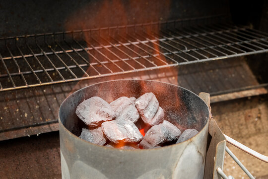 Flames rising out of charcoal chimney starter