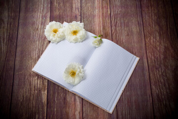 Naklejka na ściany i meble bouquet of beautiful white roses and blank notebook