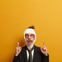 Vertical shot of surprised European man got traumas and shiners after skateboard accident,...