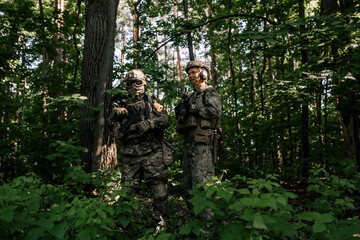 Two soldiers with weapons in the forest
