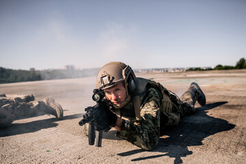 Two us army soldiers in camouflage lie on the roof of a building with a rifle storming opponents