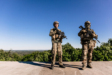 Two American army soldiers standing on the roof of a building