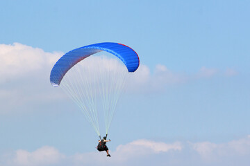 Paraglider flying wing in a blue sky	