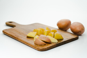 The cut potato on a chopping board with selective focus, isolated on white background