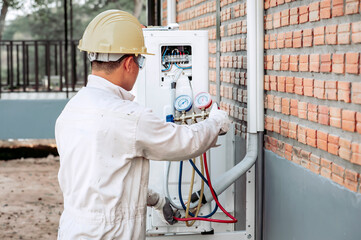 The air conditioner technician is checking the air compressor system.