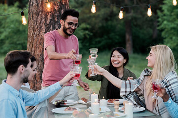 Three young intercultural couples with wineglasses toasting by served table