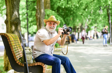 Explore city. Tourism hobby. Tourist concept. Travel and tourism. Photographer sit on bench in park. Capturing spring beauty. Enjoying free time. Walking his favorite street. Senior man hold camera