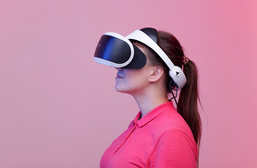 Portrait of beautiful woman in glasses of virtual reality. Augmented reality, future technology concept. VR. Pink background. Free space for text.
