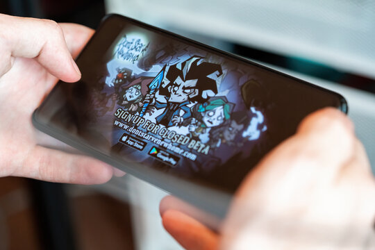 New York, USA - June 27, 2020: Donʼt Starve: Newhome game app close-up on phone screen. Hands holding a smartphone with Donʼt Starve: Newhome picture. Illustrative Editorial
