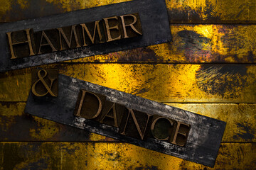 Hammer and Dance text formed with real authentic typeset letters on vintage textured silver grunge...