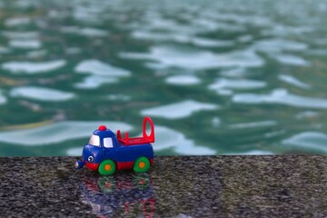 Naklejka premium toy car forgotten on the edge of fountain