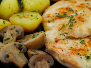 Cooked chicken breast with mushrooms and potatoes close-up