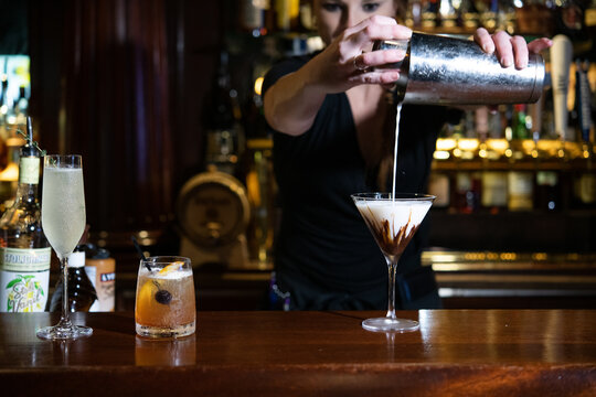 Female bartender making a cocktail at the bar