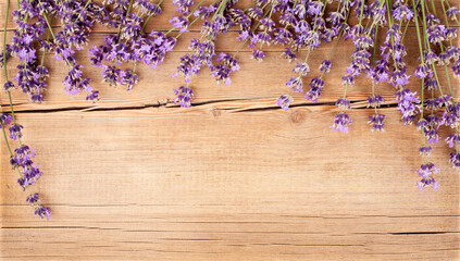 Lavender flowers on wooden background. Greeting card, top view, flat lay, copy space for text