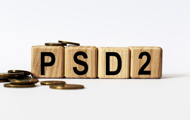 wooden cubes and PSD2, coins, the concept of taxation, increase taxes and fees