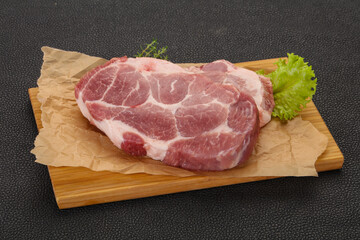 Raw pork steak over wooden board
