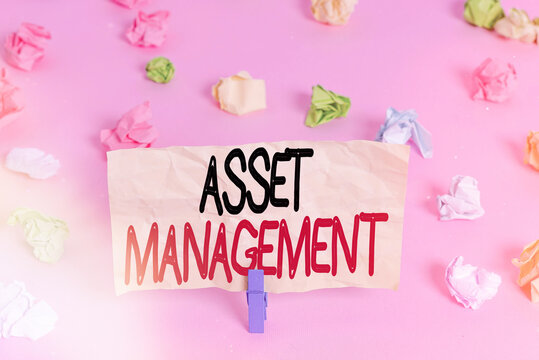 Writing note showing Asset Management. Business concept for precise handling of resources for future economic benefits Colored crumpled papers empty reminder pink floor background clothespin