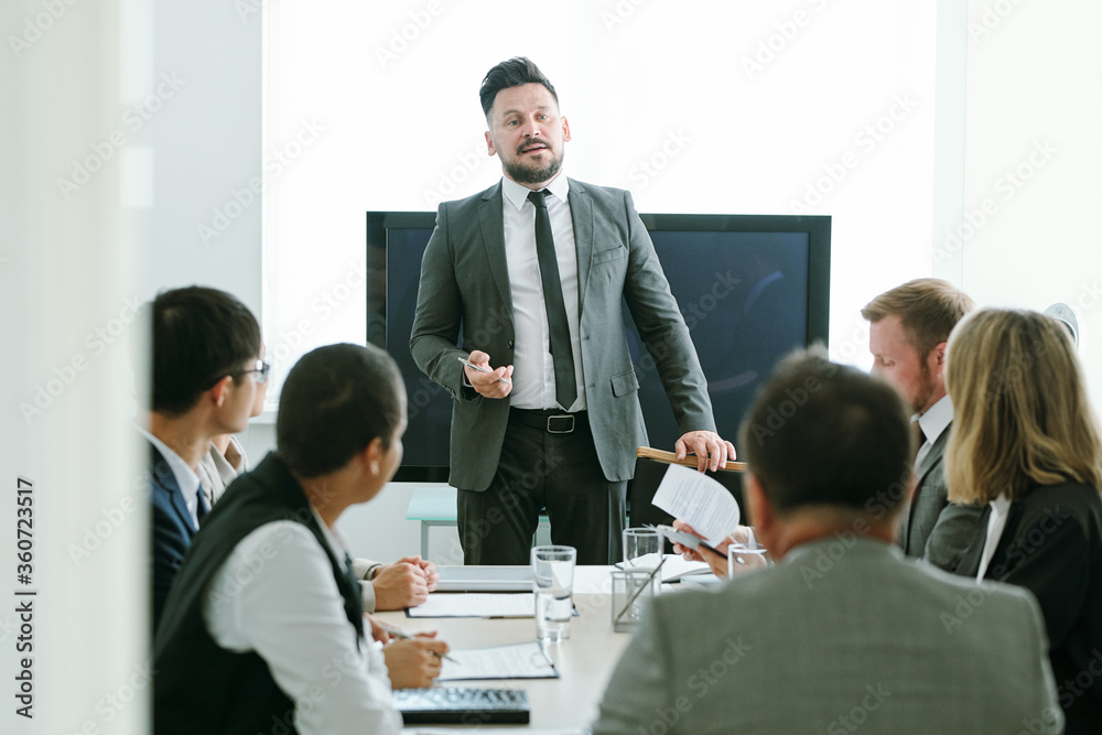 Wall mural confident middle aged businessman in formalwear making speech at training