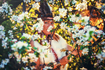 beautiful shamanic girl playing on shaman frame drum in the nature and light graphic effect.